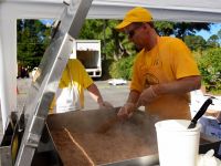 Dennis McGee stirring pulled pork in a 42 gallon tilt-skillet