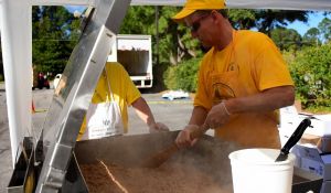 Dennis McGee stirring pulled pork in a 42 gallon tilt-skillet