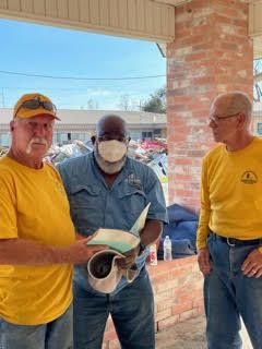 DR team members offer a Bible to a Houma resident they served.