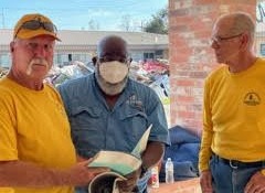DR team members offer a Bible to a Houma resident they served.